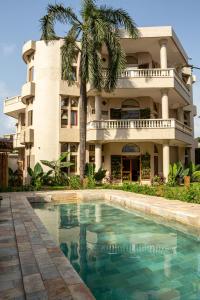 a building with a swimming pool in front of a building at Tamarin Hôtel in Cotonou