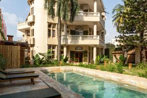 a hotel with a swimming pool in front of a building at Tamarin Hôtel Cotonou in Cotonou