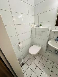 Hotel Sonnenschein nähe Messe und Flughafen في دوسلدورف: حمام ابيض مع مرحاض ومغسلة