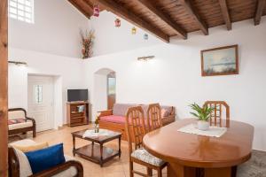 een woonkamer met een tafel en stoelen bij Holiday house with sea view and private garden in Samos