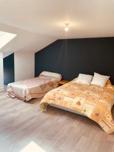 Un dormitorio con dos camas y una pared negra. en Maison de campagne, en Saint-Santin-Cantalès