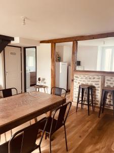 Una cocina con una mesa y sillas en una habitación. en Maison de campagne, en Saint-Santin-Cantalès