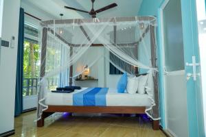 a bedroom with a bed with a canopy at Ocean's Eye Apartments in Unawatuna