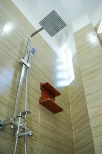 a shower with a shower head in a bathroom at Ocean's Eye Apartments in Unawatuna