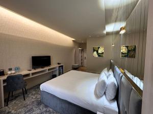 Pokój hotelowy z łóżkiem i biurkiem z telewizorem w obiekcie Barhat Resort w mieście Taraz