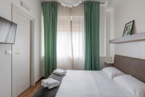 1 dormitorio con 1 cama grande y cortinas verdes en Ai piedi di San Luca - Parcheggio + 3 bagni, en Bolonia