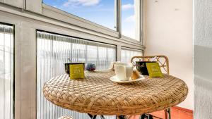 - une table en osier avec une tasse de café sur le balcon dans l'établissement COLOC HAPPY PLACE - Belle colocation de 3 chambres - Wifi gratuit, à Annemasse