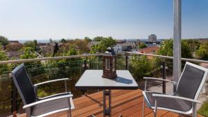 Un balcón con 2 sillas y una mesa en una terraza. en Villa am Kreidebruch _ Komfort_App en Sassnitz