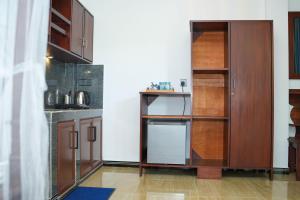 a kitchen with wooden cabinets and a counter top at Ocean's Eye Apartments in Unawatuna
