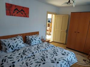 a bedroom with a bed with blue and white sheets at Casa Kasandra in Buşteni