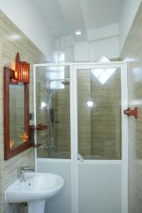 a bathroom with a sink and a shower with a glass door at Ocean's Eye Apartments in Unawatuna
