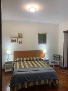 1 dormitorio con 1 cama con 2 mesas y 2 lámparas en Flavia Apartment, en Roma