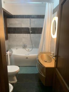 y baño con aseo, bañera y lavamanos. en Flavia Apartment, en Roma