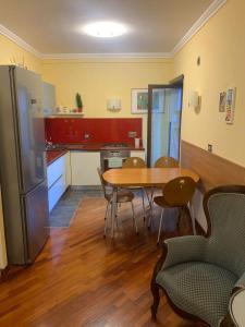 ローマにあるFlavia Apartmentのキッチン(テーブル、椅子、冷蔵庫付)