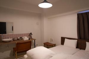 1 dormitorio con cama, escritorio y espejo en minato hotel, en Kioto