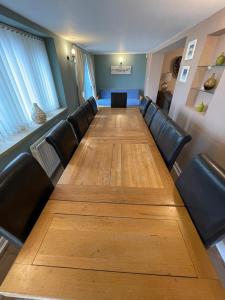uma longa mesa com cadeiras de couro e uma longa mesa de madeira em Lakeview Holidays em Whelford