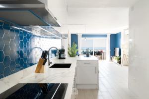 una cocina con encimeras blancas y azulejos azules en Mediterranean Way - Rits, en Salou