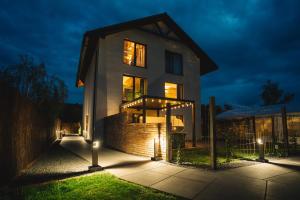 a house lit up at night with lights at H&G Boutique Apartments in Oświęcim