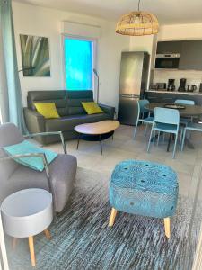 een woonkamer met een bank en een tafel bij T3 BLUE NOTE -4 étoiles- BALARUC-LES-BAINS in Balaruc-les-Bains