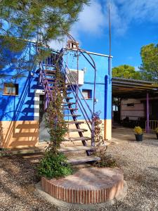 un conjunto de escaleras frente a un edificio azul en La Venta de las Estrellas Casas Rurales en Valdepeñas