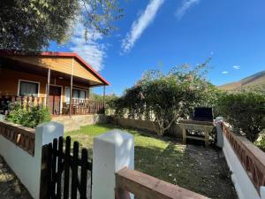 a house with a fence in front of a yard at Camping Orgiva in Órgiva