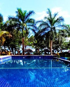 uma piscina azul com palmeiras ao fundo em Maua apartment em Dar es Salaam