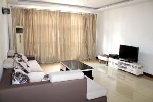uma sala de estar com um sofá e uma televisão em Maua apartment em Dar es Salaam