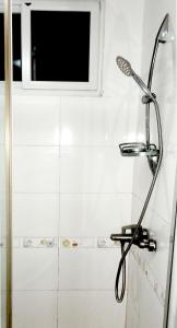 um chuveiro na casa de banho com uma janela em Maua apartment em Dar es Salaam