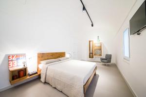 a white bedroom with a bed and a tv at B&B Casa Ninè in Gioia del Colle