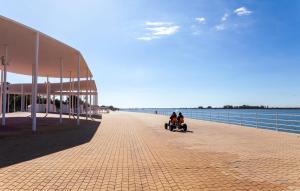 two people on a boardwalk next to the water at Vive Huelva MARINA WIFI 300 VFTHU01194 in Huelva