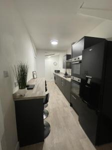 a large kitchen with black cabinets and a counter at Village Lodge in Middlesbrough