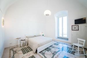 ein weißes Schlafzimmer mit einem Bett und einem Fenster in der Unterkunft B&B Casa Ninè in Gioia del Colle