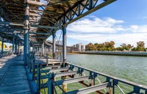 a pier with benches next to a body of water at Vive Huelva MARINA WIFI 300 VFTHU01194 in Huelva