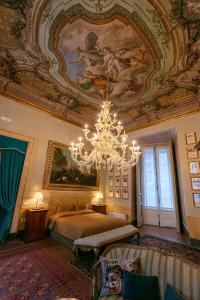 a bedroom with a chandelier and a painting on the ceiling at Palazzo Doria Napoli in Naples +89 photos