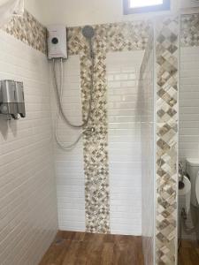 a shower with a shower head in a bathroom at The Pubpa Backyard 