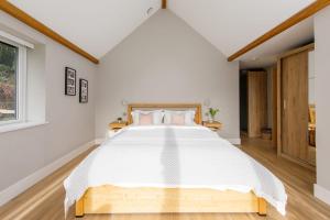 a white bedroom with a large bed with white sheets at Luxury Cottage Conversion ~ Close to Beaches in Birdham
