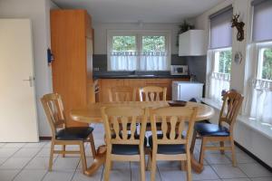 cocina con mesa de madera y sillas en Duinland 34, en Sint Maartensvlotbrug