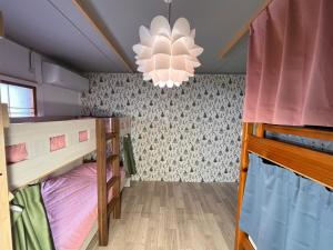 a room with two bunk beds and a chandelier at TOTONOU Place in Asahikawa