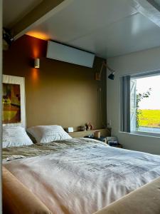 um quarto com uma cama grande e uma janela em Amazing Guesthouse in Broek in Waterland em Broek in Waterland