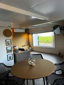 Amazing Guesthouse in Broek in Waterland في بروك إن ووترلاند: غرفة مع طاولة وكراسي وأريكة