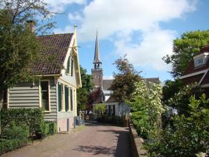 una calle en una pequeña ciudad con una torre de reloj en Amazing Guesthouse in Broek in Waterland, en Broek in Waterland