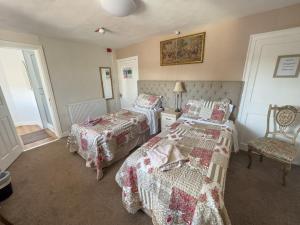 a bedroom with two beds and a chair at The Vintage Inn in Wellington