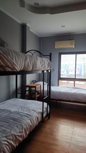 Zimmer mit 2 Etagenbetten und einem Fenster in der Unterkunft The Garden in Thongsala