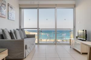 ein Wohnzimmer mit einem Sofa und Meerblick in der Unterkunft Stunning one-bedroom apartment with sea views in Protaras