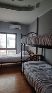 2 Etagenbetten in einem Zimmer mit Fenster in der Unterkunft The Garden in Thongsala