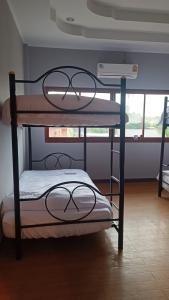 two bunk beds in a room with a window at The Garden in Thongsala