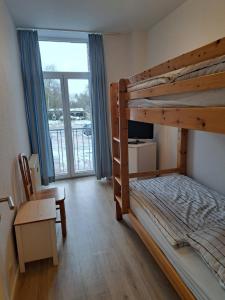 1 dormitorio con litera, escritorio y ventana en Apartmenthaus Hartl, en Barmstedt