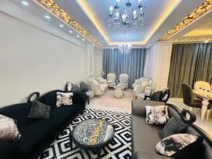 a living room with couches and a chandelier at برج الولاء بالغشام شقة فندقية Vip in Manshīyat as Sādāt