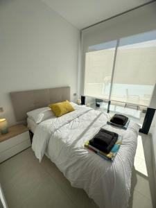 Un dormitorio con una cama blanca con toallas. en Prestige Apartament III, en Torrevieja