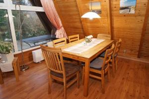 a dining room with a wooden table and chairs at Zeltdachhaus mit grossem Grundstue in Damp